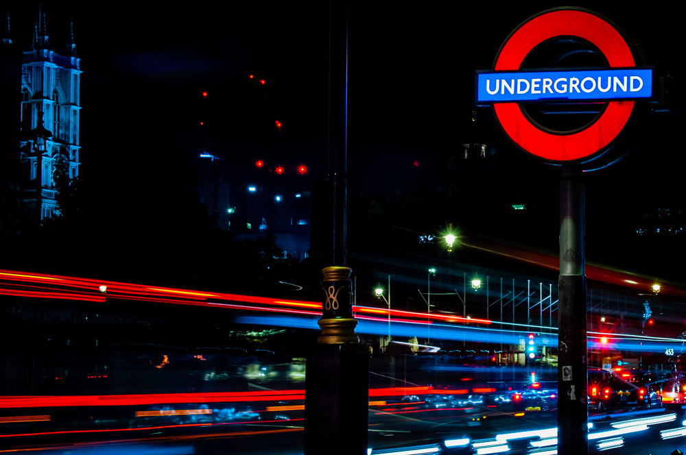 red blue london underground entrance sign and street