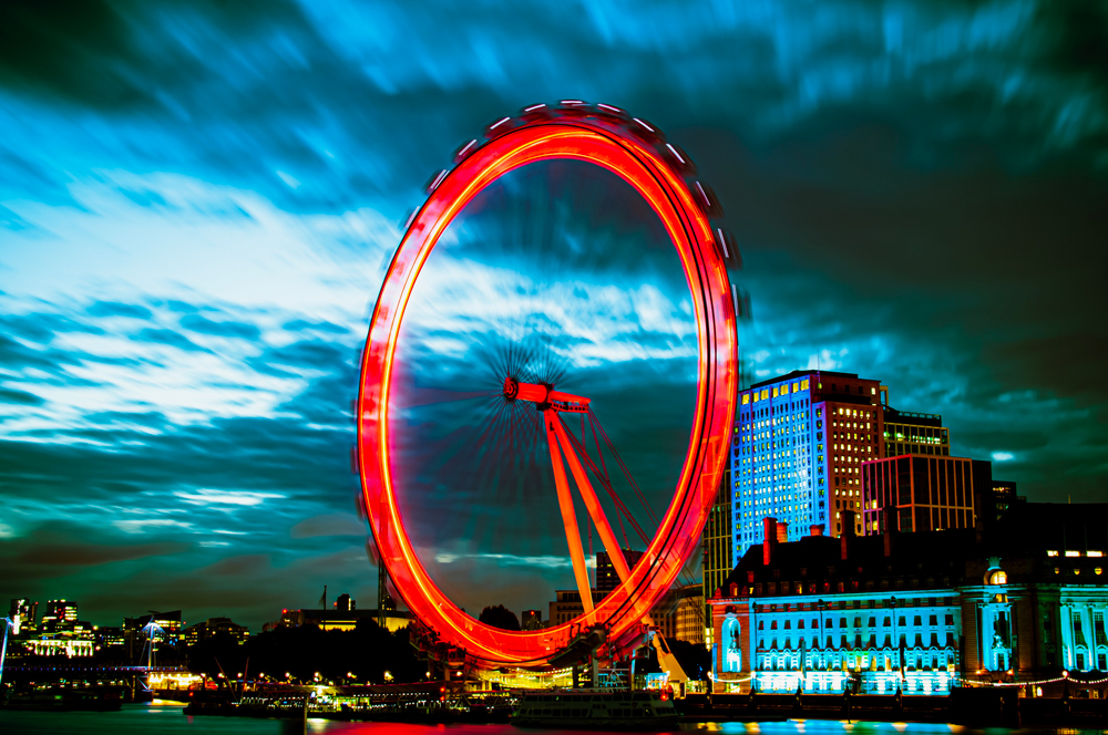 long exposure shot of london eye lit in red 