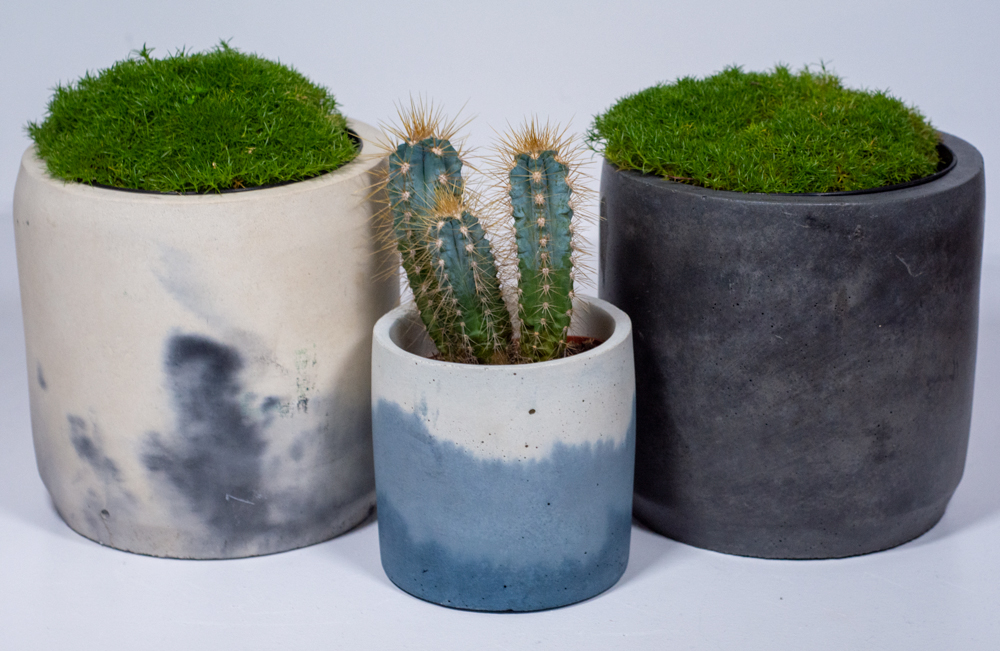 three concrete plant pots two with marbled and tie dyed effect