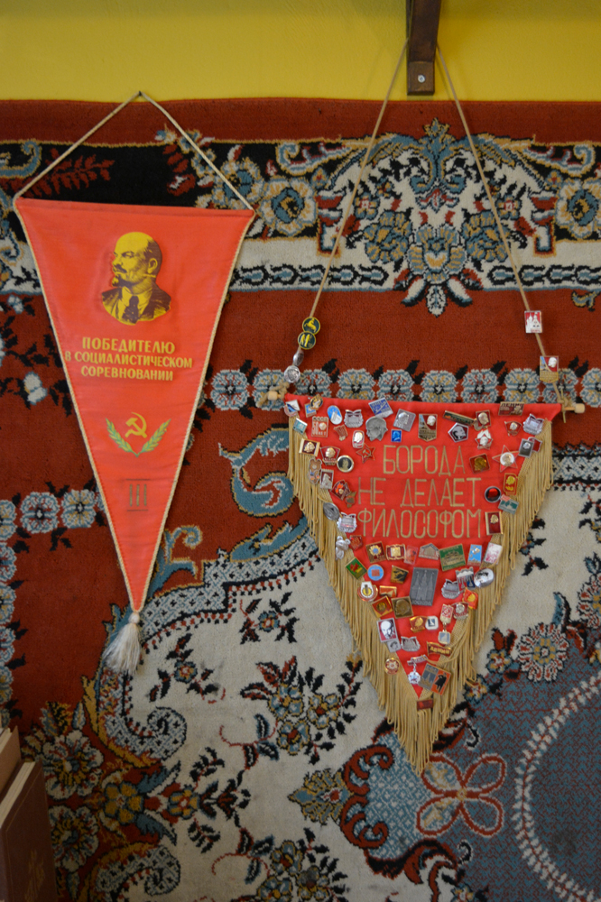 soviet red banners and badges against wall hanging carpet