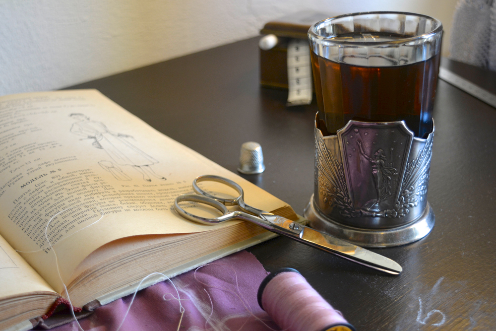 russian book, scissors and glass of tea 