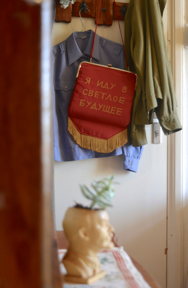 red bag with message in russian and lenin's head as a plant pot holder 