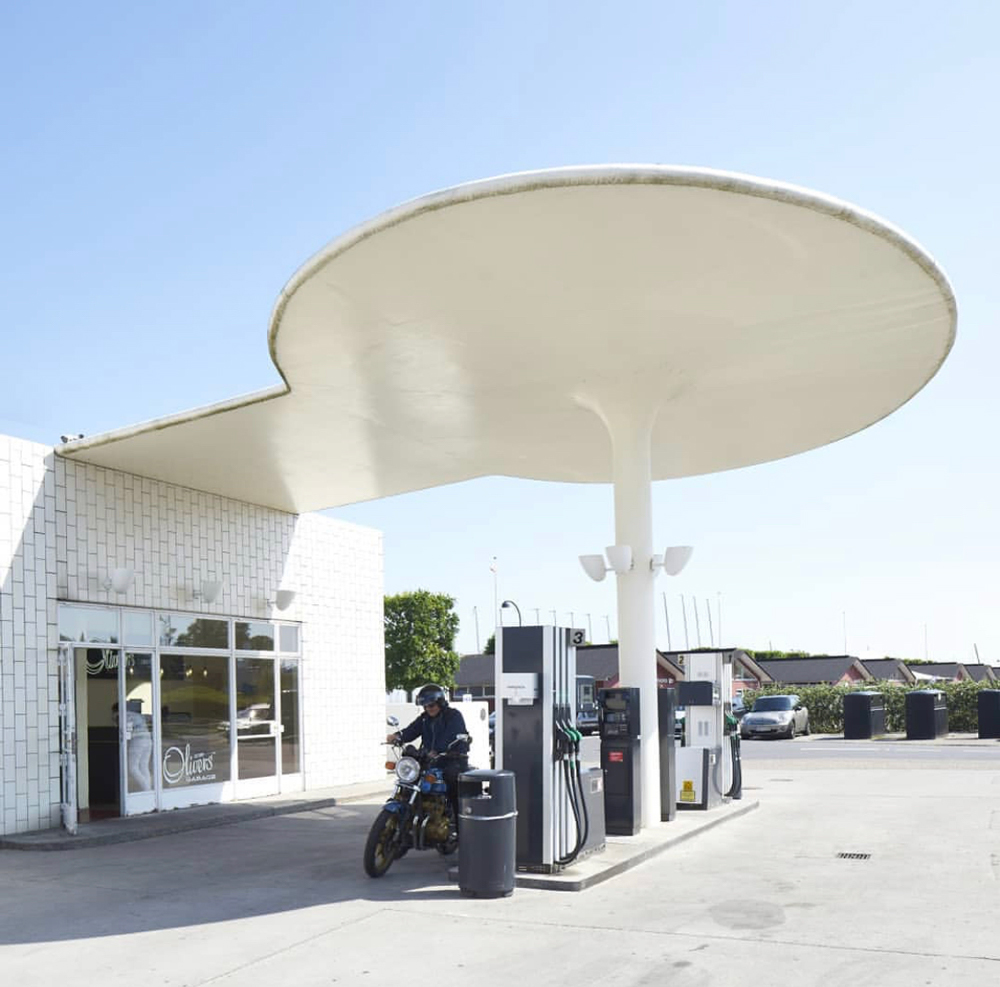 Forecourt of petrol station with motor cyclist in black leathers