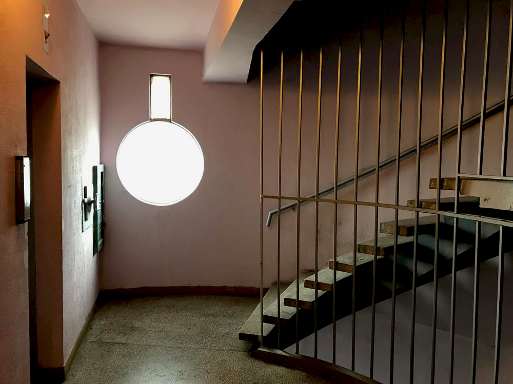 staircase with pink walls inside genex tower on 29th floor with distinct window design