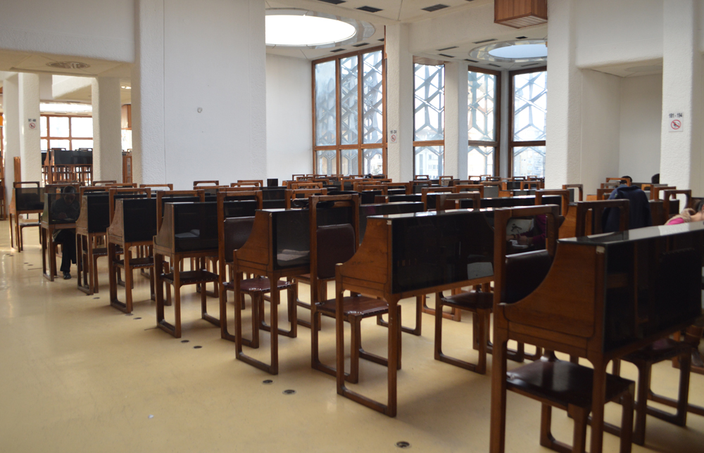 room with rows of chairs and windows with small view of facade