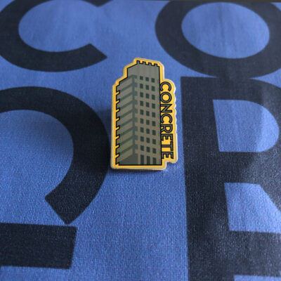 grey metal badge with yellow background with word concrete graphic design of barbican