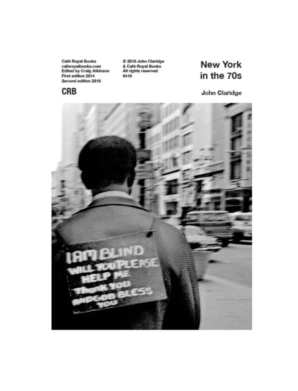 black and white photo of man with sign on back I am blind