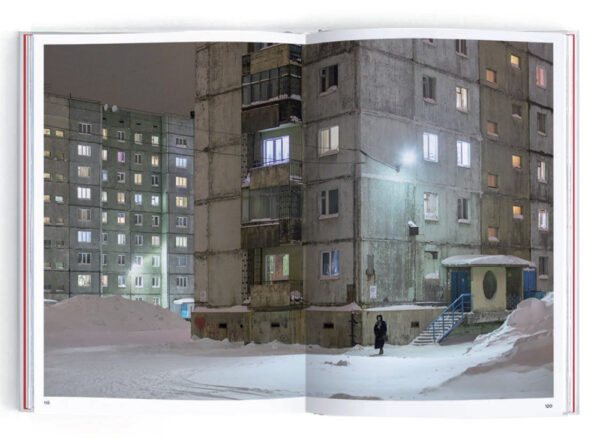 apartment block with resident standing in the snow