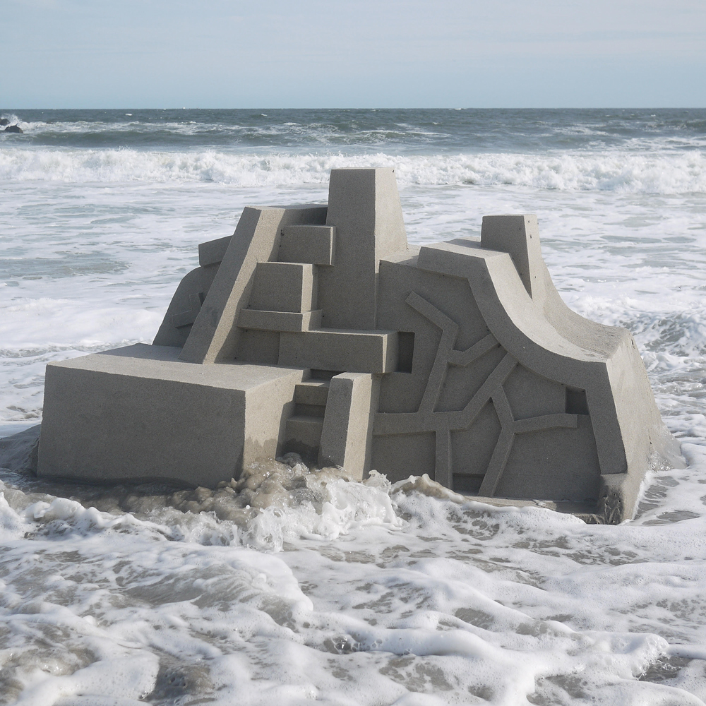 waves lapping around one of Calvin Seibert's sandcastles