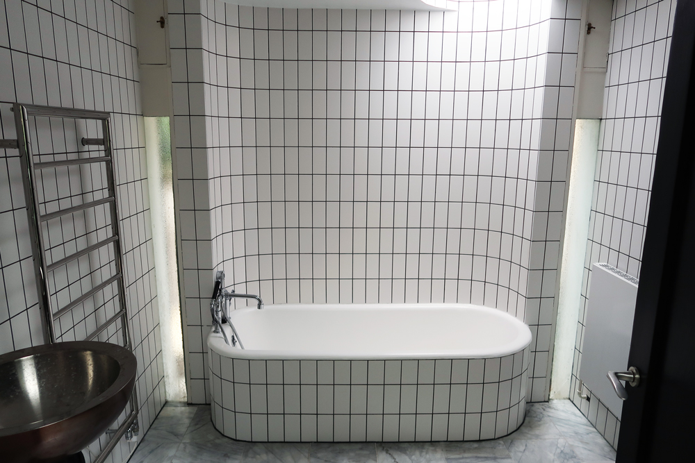 bathroom with white tiles and black grout 